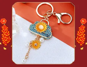Sunflower cloud bag keychain with blue rhinestones and pearls, metal key ring pendant detail.
