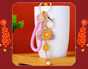 Exquisite sunflower small bag car keychain with rhinestone metal ring and pearl pendant.