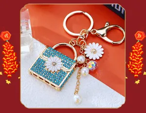 Detailed view of the sparkling blue rhinestone bag keychain with cute white daisy charm.