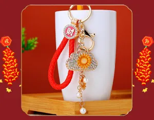 Sunflower mini bag rhinestone keychain, detailed metal pendant with red braided strap.