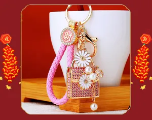 Close-up detail of the pink rhinestone mini bag keychain with white daisy and pearl charms.
