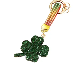 Portachiavi quadrifoglio in strass scintillante con cinturino sfumato e accessori dorati chic.