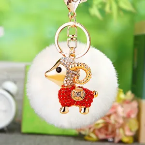 Cute plush sheep keychain with golden metal ring and white fluffy pom pom bag charm pendant.