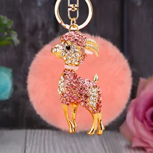 Rhinestone goat plush keychain detail, cute metal key ring and furry pom-pom bag pendant.