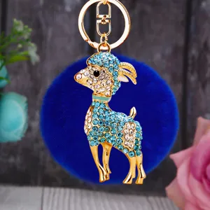 Close-up view showing glittering rhinestones and golden details on the plush goat keychain.