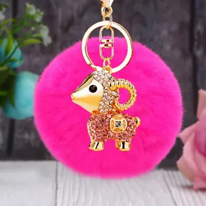 Detailed close-up of a sparkling rhinestone ram keychain with hot pink fluffy pom-pom charm.