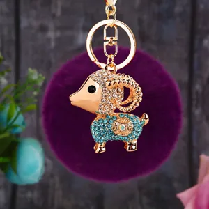Detail shot of a sparkling rhinestone sheep charm keychain with a soft purple plush ball.