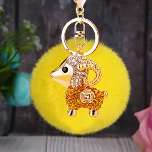 Close-up detail view of the sparkling rhinestone sheep keychain with fluffy yellow pom-pom.