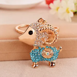 Close-up detail of a cute rhinestone sheep keychain, sparkling crystals and gold-tone metal.