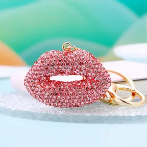 Close-up view of the sparkling pink rhinestone lip keychain, showcasing crystal details and gold hardware.