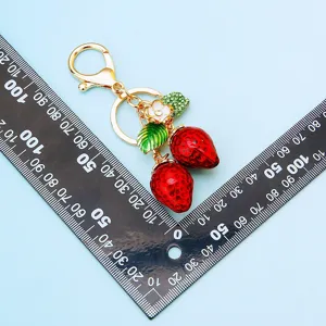 Grazioso portachiavi in metallo a doppia fragola con strass, perfetto pendente per borsa e auto.