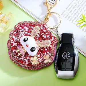 Detailed view of a glittering rhinestone rabbit mirror keychain and bag charm with pearls.