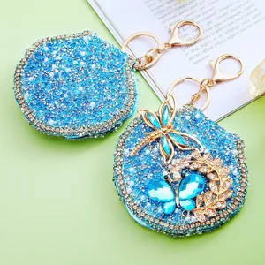 Detailed view of the sparkling rhinestone shell compact mirror keychain with cute charms.