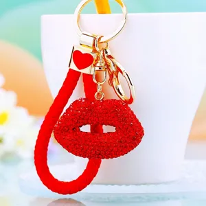 Sparkling rhinestone red lips keychain with red braided rope and gold hardware for bags.