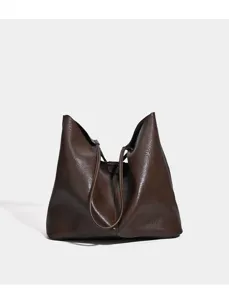 Brown PU leather slouchy tote bag detail, minimalist commuter shoulder handbag texture.