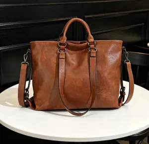 Detail view of brown soft leather tote bag, showing large capacity and double handle design.