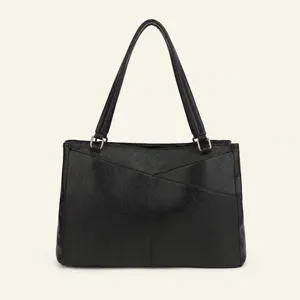 Schwarze Handtasche Detailansicht mit mehreren Fächern und geometrischen Ziernähten.