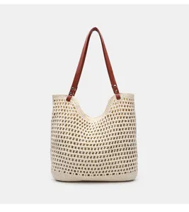 Detailansicht der geflochtenen Strohtasche mit Häkeldesign und braunen Ledergriffen.
