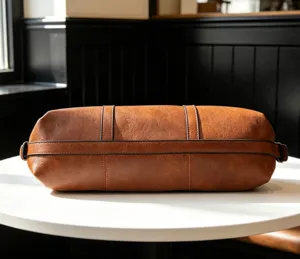 Detail shot of brown soft leather cylindrical handbag, fashion shoulder tote bag for women.