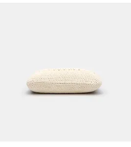 Nahaufnahme eines beige gewebten Strick-Clutch-Täschchens, das die feine Textur zeigt.