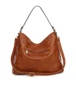 Detailed view of the brown leather shoulder bag zipper pocket and adjustable strap.