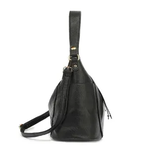 Detail view of black textured women's shoulder crossbody bucket bag with gold hardware.