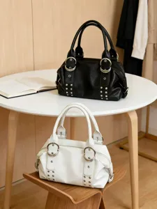 Detailansicht der weichen Leder-Umhängetasche mit Metallringen und Nieten in Schwarz und Weiß.