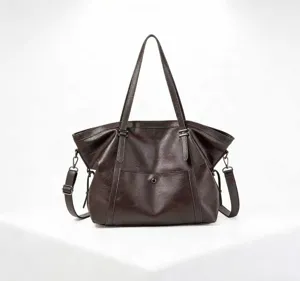 Detalle de bolso tote de cuero PU suave, textura marrón oscuro, herrajes vintage.