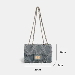 Denim quilted chain shoulder bag with frayed edge and metal turn lock closure.