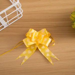 Gedetailleerde close-up van een heldergele geschenkstrik versierd met schattige witte hartjes.