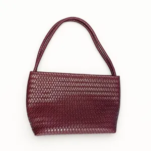 Woven leather shoulder bag detail, dark red minimalist design, elegant everyday accessory for women.