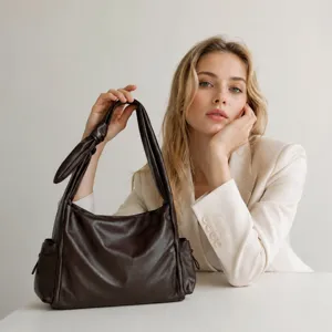 Detail view of a dark brown soft leather slouchy shoulder bag with unique knotted handle.