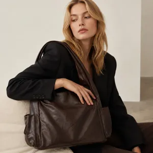 Detailed view of the dark brown slouchy leather tote bag with side pockets and shoulder strap.
