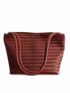 Close-up detail of the woven leather texture, displaying the premium brown finish on the tote bag.