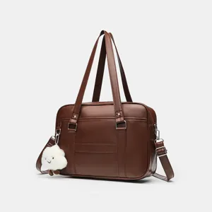 Brown PU leather JK school bag detail view, showing sturdy handles and cute cloud pendant.