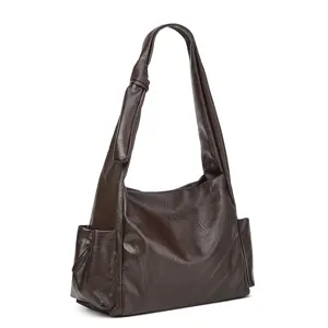 Dark brown shoulder bag detail showing the unique knotted strap and side pocket design.