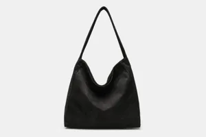 Close-up detail of the black faux suede shoulder bag showing soft texture and stitching.