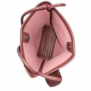 Woven leather bucket bag interior detail showing pink lining and magnetic snap hardware.