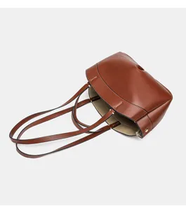 Braune Leder-Tasche Detail, minimalistisches Design mit doppelten Henkeln und offenem Top.