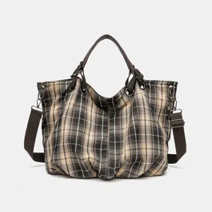 Detail view of the vintage plaid canvas tote bag, featuring durable brown straps and spacious interior.