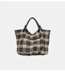 Detailed view of the vintage plaid canvas tote bag with sturdy handles and front zip pocket.