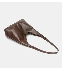Vista detallada del elegante bolso de hombro vintage marrón con textura de cuero.