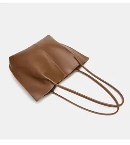 Braune Leder-Tote-Bag im Detail, mit doppelten Schultergriffen und grossem Alltagsformat.