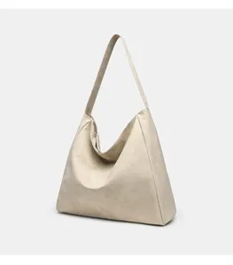 Détail de sac porté épaule beige souple, cabas hobo minimaliste doux à texture lisse et élégante.