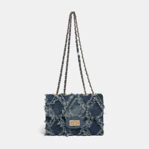 Quilted denim chain crossbody bag with frayed patchwork design and stylish metal twist lock.