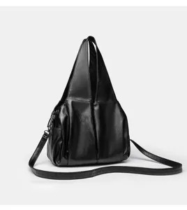 Detailansicht der schwarzen weichen Ledertasche mit Textur, Griffen und Riemendesign.