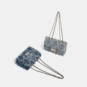 Distressed denim shoulder chain bag with classic metal turn-lock and quilted design details.