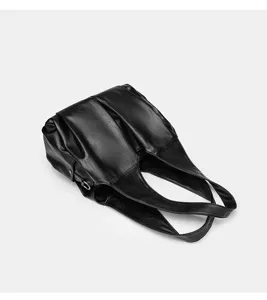 Detaillierte Nahaufnahme der eleganten schwarzen Lederschultertasche mit plissierter Textur.