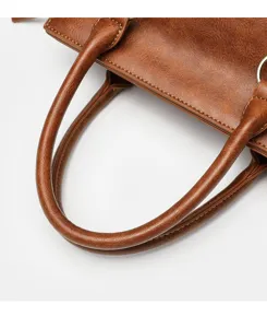 Gros plan sur la poignée de sac à main vintage en cuir PU avec belles coutures.
