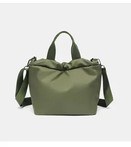 Détail de sac bandoulière en tissu oxford vert, cabas décontracté léger avec sangle solide.